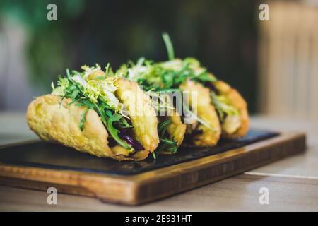 Four mexican tacos with meat, cabbage and cheese sauce Stock Photo