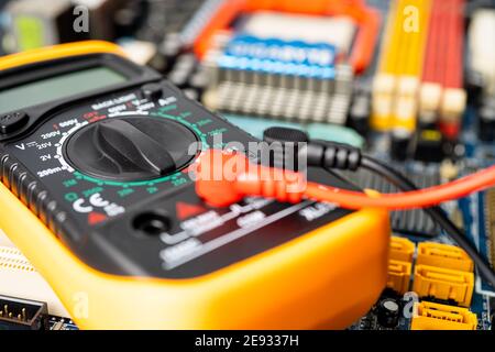 Multimeter with main board, maintenance, repairing and checking computer hardware concept. Stock Photo