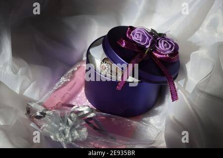 Silver Diamond ruby engagement ring in Purple open box with flowers and Gift Card with white background for text Stock Photo