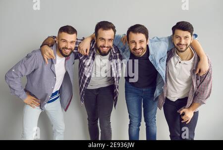 Group portrait of happy young friends hugging, smiling and having fun in the studio Stock Photo