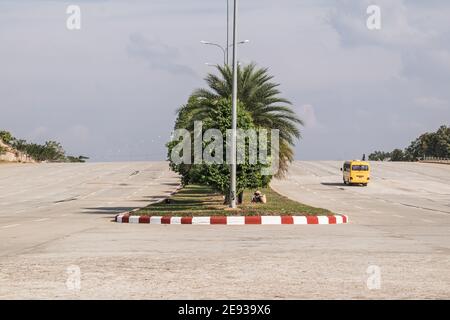 NAY PYI TAW, MYANMAR (BURMA) - Dec 31, 2015: Yellow school bus driving on a massive 16 lanes wide empty road. Stock Photo