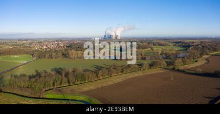 panoramic aerial view of large traditional power station with wind turbines and surrounding area of town and farmland Stock Photo