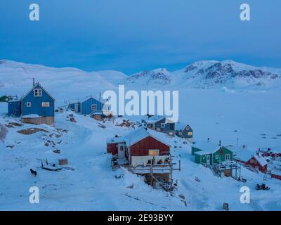 During dawn hunters are returning to their village using snowmobiles. The traditional and remote greenlandic inuit village Kullorsuaq located at the Stock Photo