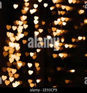 Gold background bokeh lights heart, valentine backgrounds, blurred sparkle for night backdrop. Defocused Theme of love banner. Loving, positive emotio Stock Photo