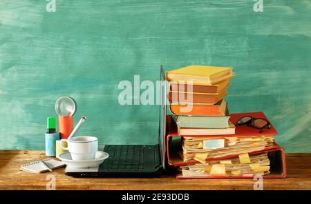 home offiice,education,business,homeschooling concept with laptop computer row of books, file folders, office supplies and cup of coffee Stock Photo