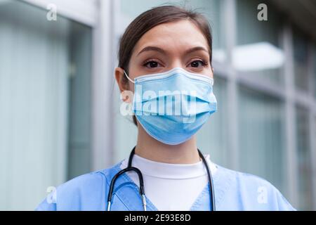 Closeup portrait of very tired exhausted UK NHS ICU doctor in front of hospital,Coronavirus COVID-19 pandemic outbreak crisis,sleep deprived EMS medic Stock Photo