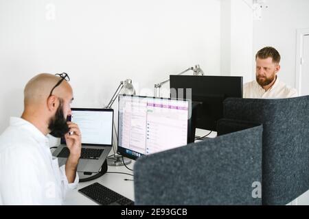 Men working on computers in office Stock Photo