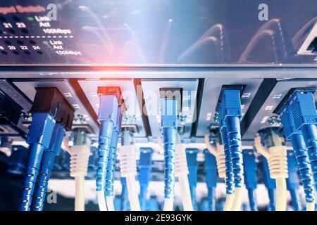 Fiber Optic cables connected to optic ports and Network cables connected to ethernet ports Stock Photo