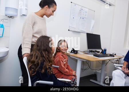 Mother with daughters visiting doctor in health center Stock Photo