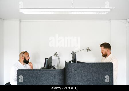 Men working on computers in office Stock Photo