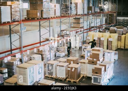 Female and male colleagues examining packages at distribution warehouse Stock Photo