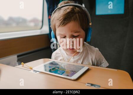 Boy in train using tablet Stock Photo