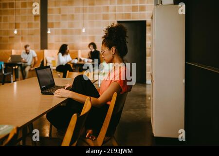 Businesswoman using laptop while working in coworking office Stock Photo