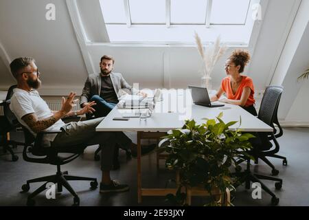 Female and male colleagues discussing during office meeting in boardroom Stock Photo