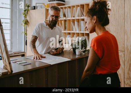 Businessman discussing with female colleague over document in office Stock Photo