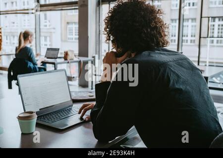 Businessman using laptop while sitting in coworking space Stock Photo