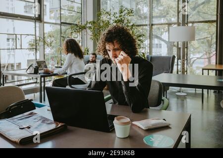 Thoughtful businessman working on laptop at office Stock Photo