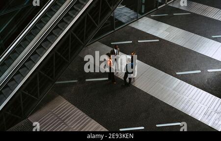 High angle view of male entrepreneurs discussing with female colleagues in meeting on walkway Stock Photo