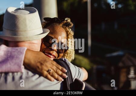 Senior woman embracing man on sunny day Stock Photo