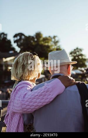 Senior woman with arm around man on sunny day Stock Photo