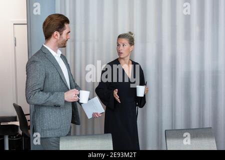 Coworkers talking in boardroom Stock Photo