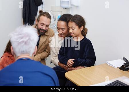 Parents with daughter visiting doctor in health center Stock Photo