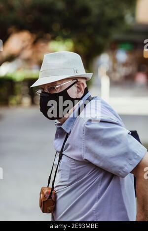 Senior man with protective face mask standing in park Stock Photo