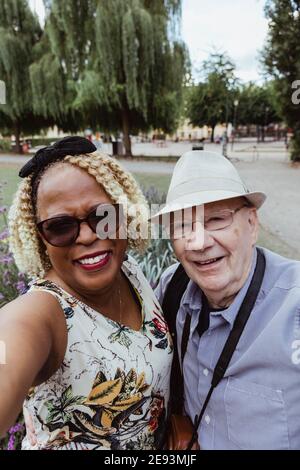 Smiling senior couple taking selfie in park during vacation Stock Photo