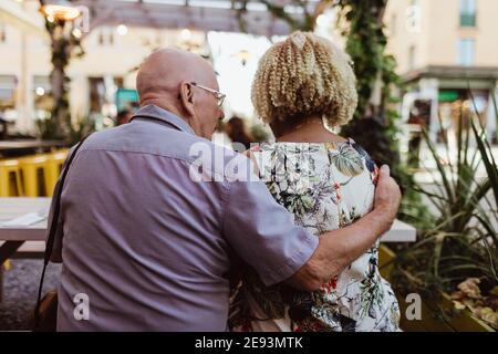 Rear view of senior couple sitting in cafe during vacation Stock Photo