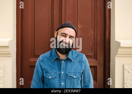 Smiling man standing against door Stock Photo