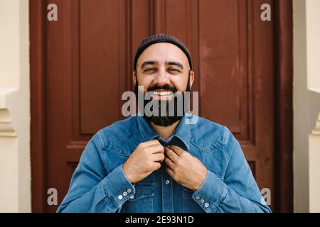 Smiling man standing against door Stock Photo