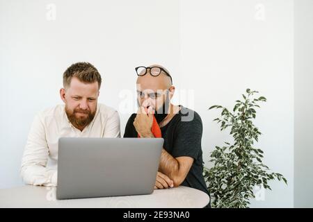 Men using laptop in office Stock Photo