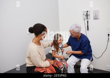 Doctor examining girl in health center Stock Photo