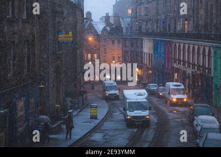 Edinburgh, Scotland - January 16 2018: A wild snowstorm and winter snowfall over pedestrians in the old town on Victoria Street and its colourful stor Stock Photo