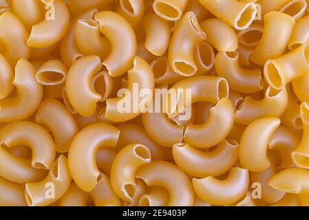 Close view of organic elbow macaroni illuminated with natural light. Stock Photo