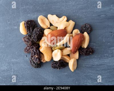 Top view of a portion of nuts and dried fruit on a blue painted wood background. Stock Photo