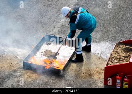 Moscow, Russia - August 25, 2018: Work extinguishes a fire in the trough with sand. Primary extinguishing media Stock Photo