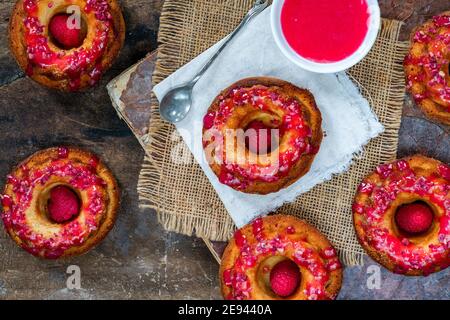 Mini vanilla pound cakes with raspberry icing - overhead view Stock Photo