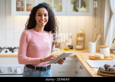 Modern Technologies In Daily Life. Happy Woman With Digital Tablet In Kitchen Stock Photo