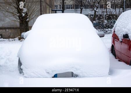 Car under thick blanket of snow after storm. Vehicles buried under ice. Nobody Stock Photo