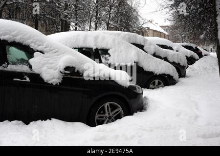 Car under thick blanket of snow after storm. Vehicles buried under ice. Nobody Stock Photo