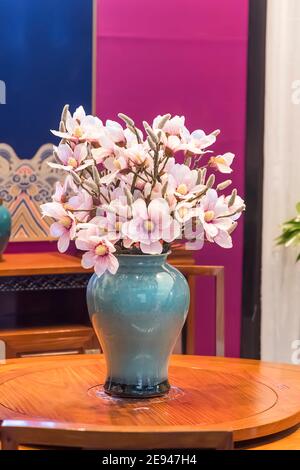 Interior design with a vase and artificial Magnolia flowers on the table. Stock Photo