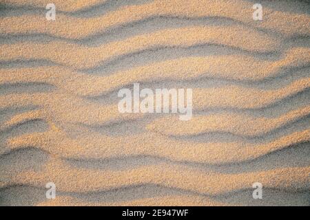 Abstract view of natural sand dune formation at the beach. Curly sand wave pattern closeup. Beautiful sandy background. Nobody Stock Photo