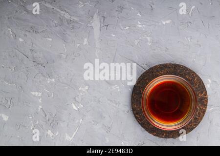 Pu erh tea cake and chinese tea cup on plaster background with place for text Stock Photo