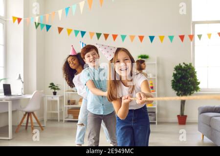 Children's team has fun and plays a game of tug of war at a festive party in honor of the birthday. Stock Photo