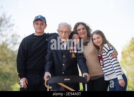 File photo dated 16/04/2020 of the then 99-year-old war veteran Captain Tom Moore, with (left to right) grandson Benji, daughter Hannah Ingram-Moore and granddaughter Georgia, at his home in Marston Moretaine, Bedfordshire, after he achieved his goal of 100 laps of his garden. Captain Sir Tom Moore has died at the age of 100 after testing positive for Covid-19, his daughters Hannah and Lucy said in a statement. Issue date: Tuesday February 2, 2021. Stock Photo