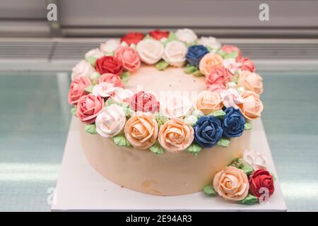 beautiful homemade cake in the form of a unicorn with cream colored flowers on table Stock Photo