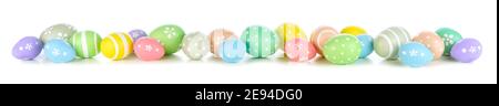 Easter eggs scattered forming a long border isolated on a white background. Pastel colors. Stock Photo