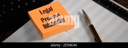 Outsourcing concept. Close-up of a memory stick with the word Legal Process Outsourcing in workplace manager. Selective focus. Stock Photo