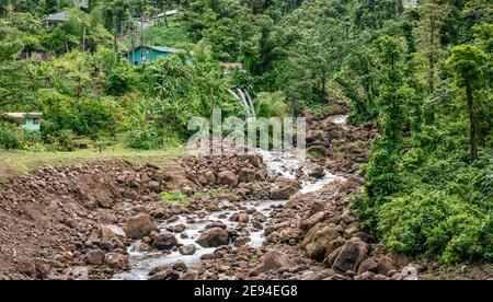 Stream through a rocky river in nature of Dominica. Stock Photo